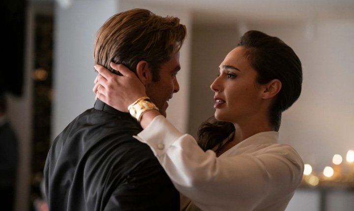 Diana Prince tenderly holds Steve Trevor’s face as they share a heartfelt moment in a warmly lit room.