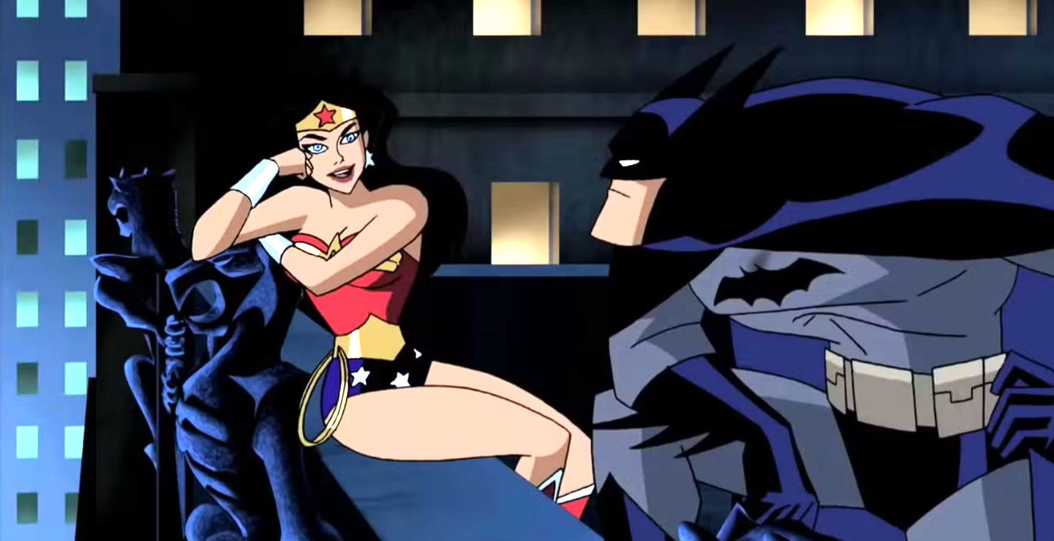 Wonder Woman playfully chats with a stoic Batman while sitting on a rooftop gargoyle at night in Justice League Unlimited.